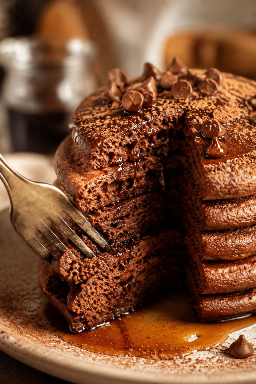 Portrait/Pinterest format () close-up macro shot of a fork cutting through a thick stack of chocolate protein pancakes